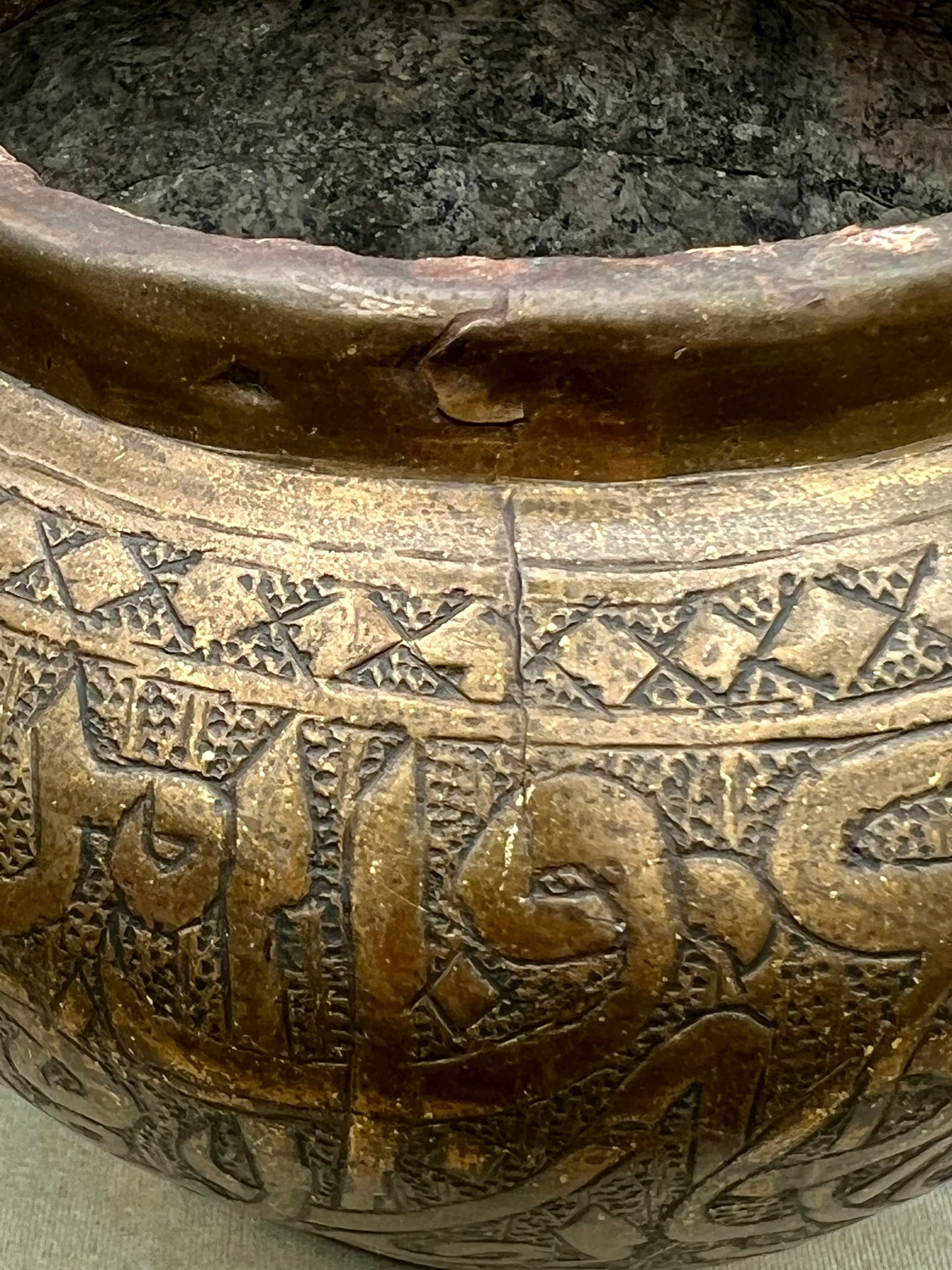 Close-up of an ancient bronze pot with intricate designs and inscriptions.