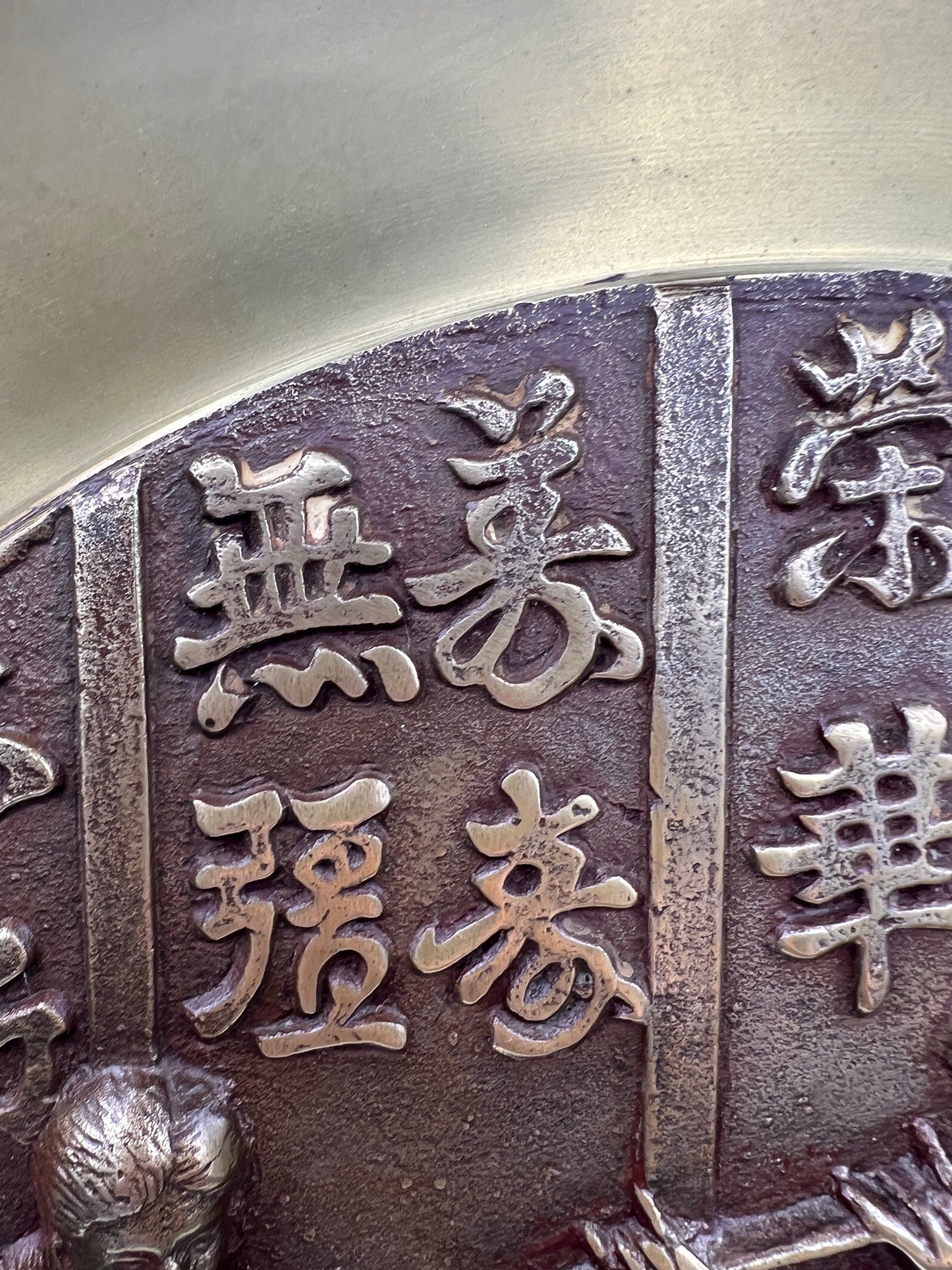 Close-up of a metallic platter with engraved characters on a neutral background