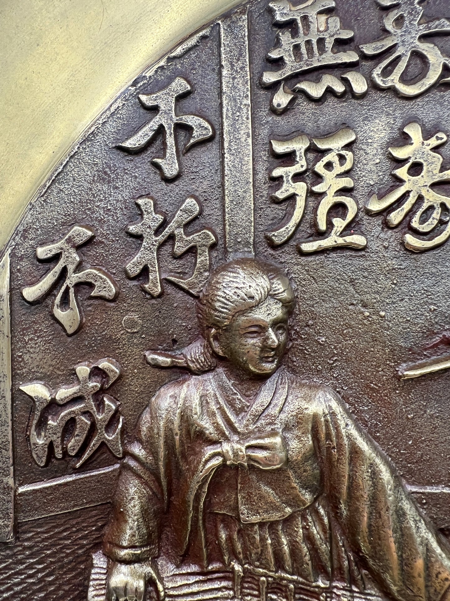 Bronze platter with engraved text and a figure of a person on a horse
