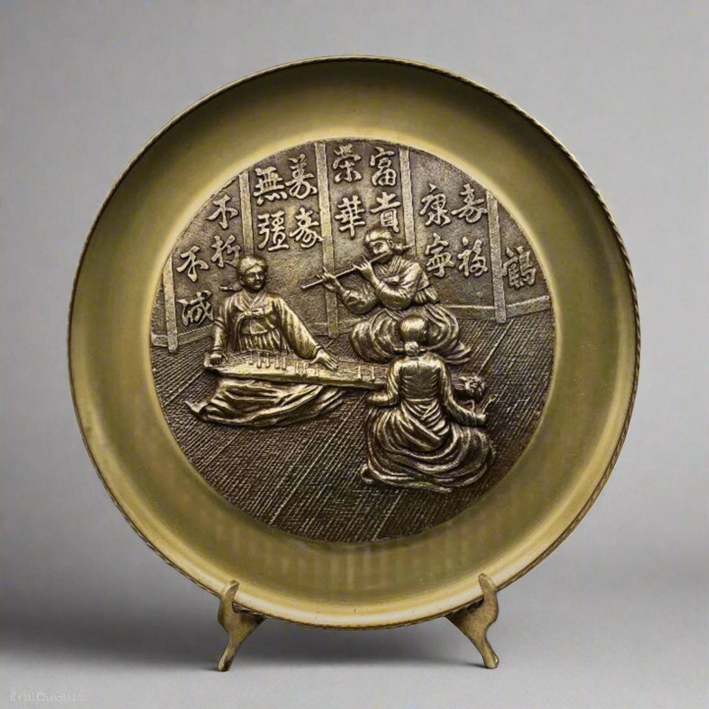 Decorative plate with embossed design on a stand against a gray background