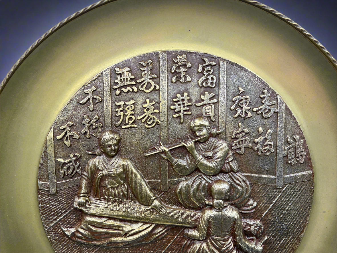 Decorative coin with two figures playing musical instruments and Chinese characters on a blue background