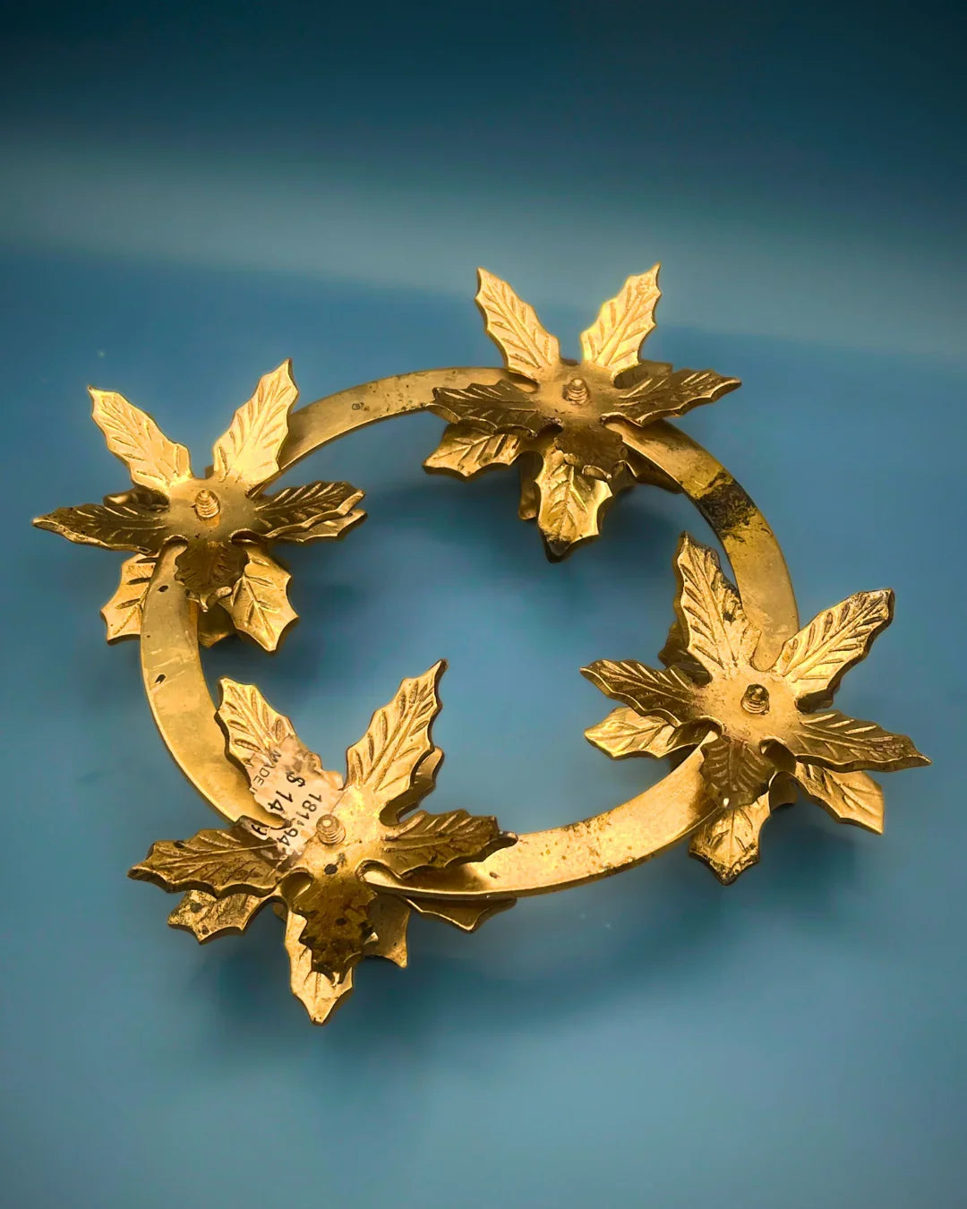 Decorative gold wreath with leaf designs on a blue background
