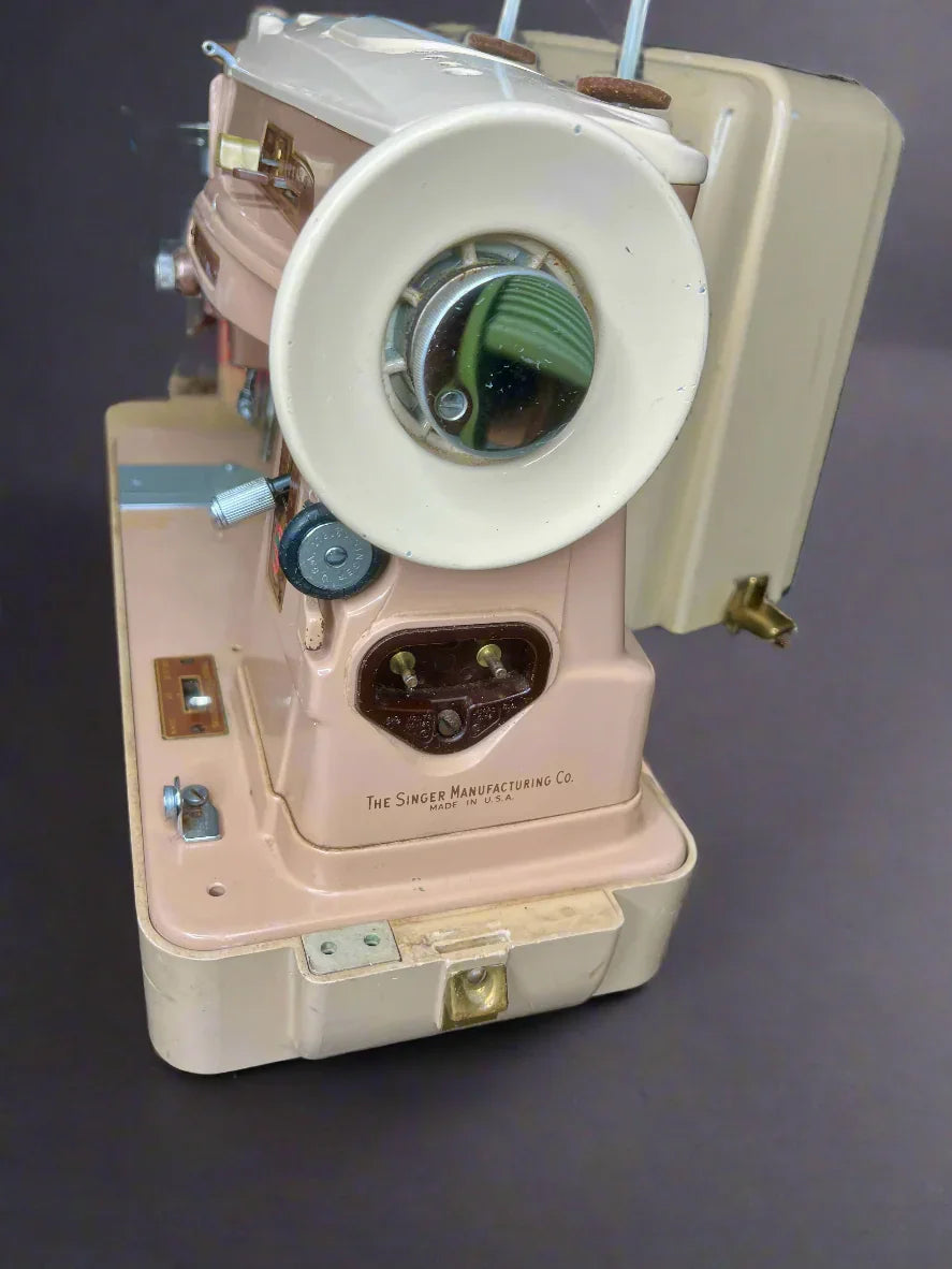 Vintage pink sewing machine on a dark surface