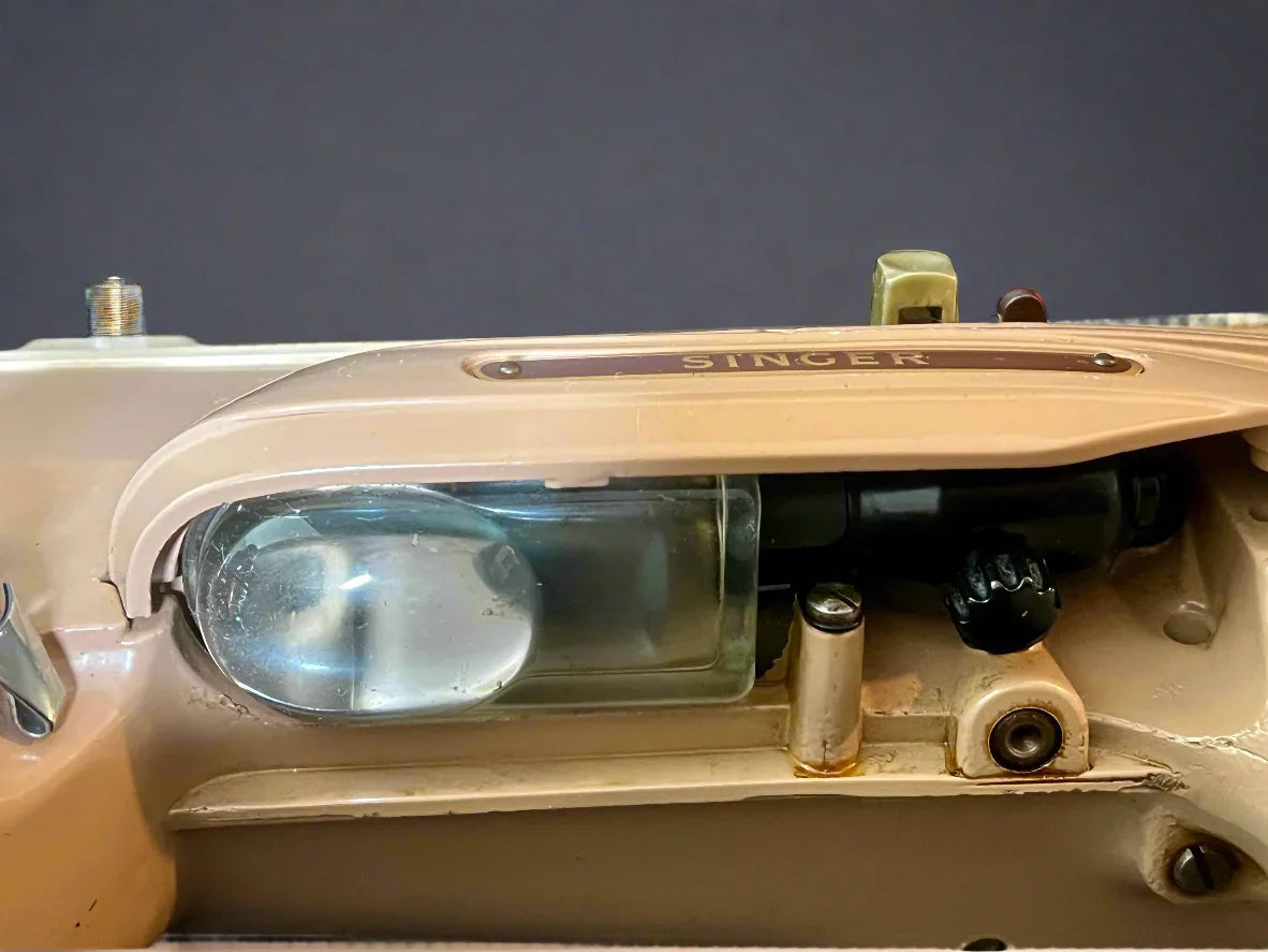 Close-up of a Singer sewing machine lens and control panel.