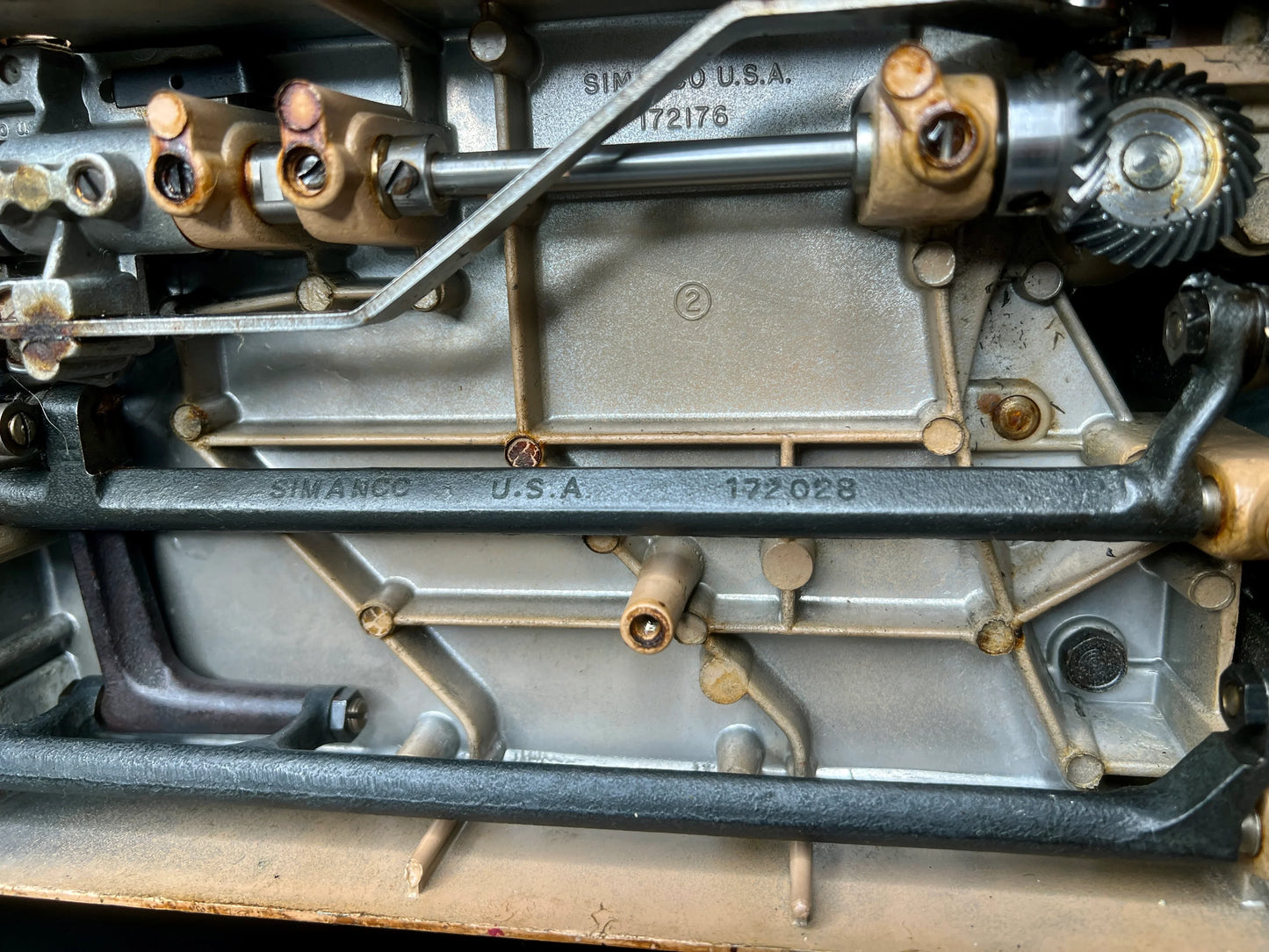 Metallic engine component with 'Simanco U.S.A.' branding on interior mechanics of Singer 403A Slant-O-Matic sewing machine