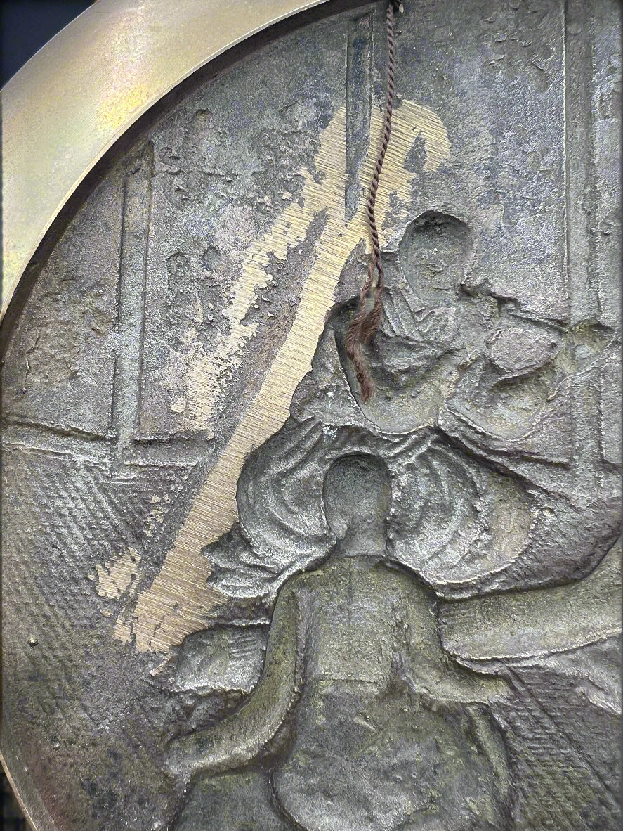 Decorative metal plate with embossed figures and intricate details