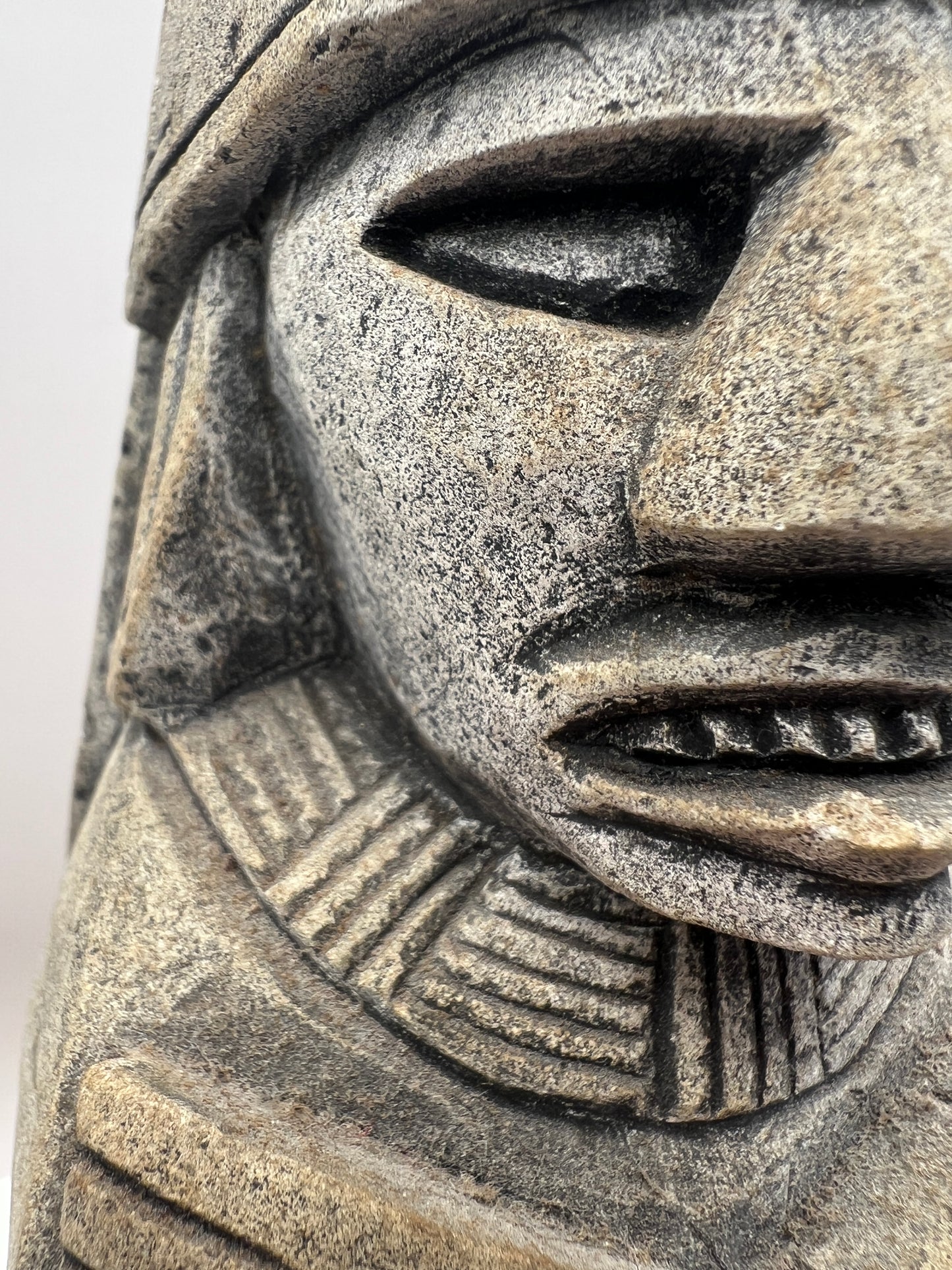 Close-up of a stone sculpture with intricate patterns on a white background