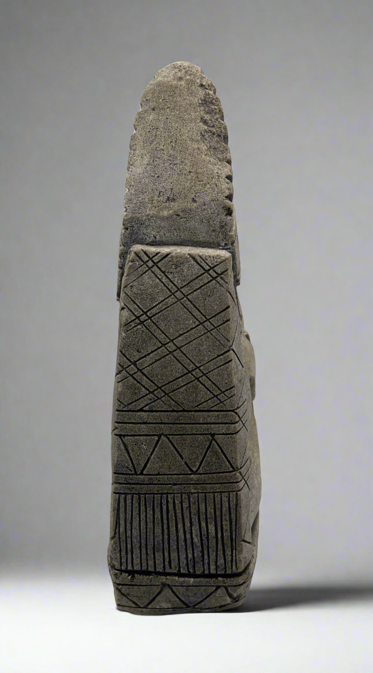 Close-up of a textured stone object with geometric patterns on a gray background