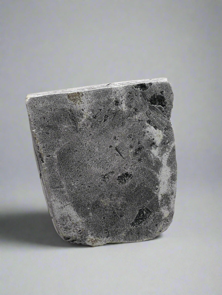 Bottom of stone statue with a textured surface on a white background