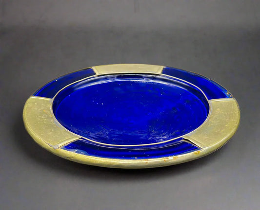 Blue ceramic plate with gold rim on a white background