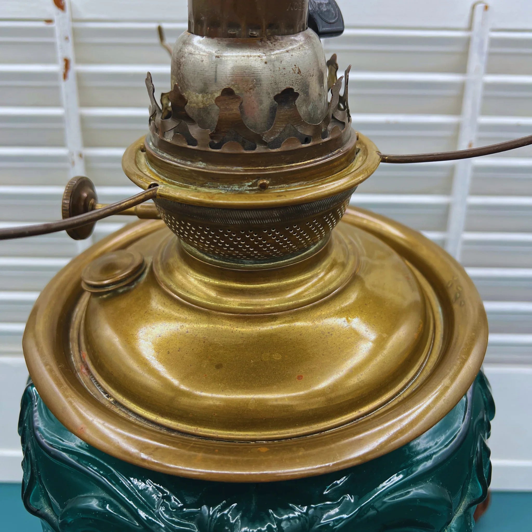 Antique Success converted oil lamp with emerald green glass and hand-painted lily motif.