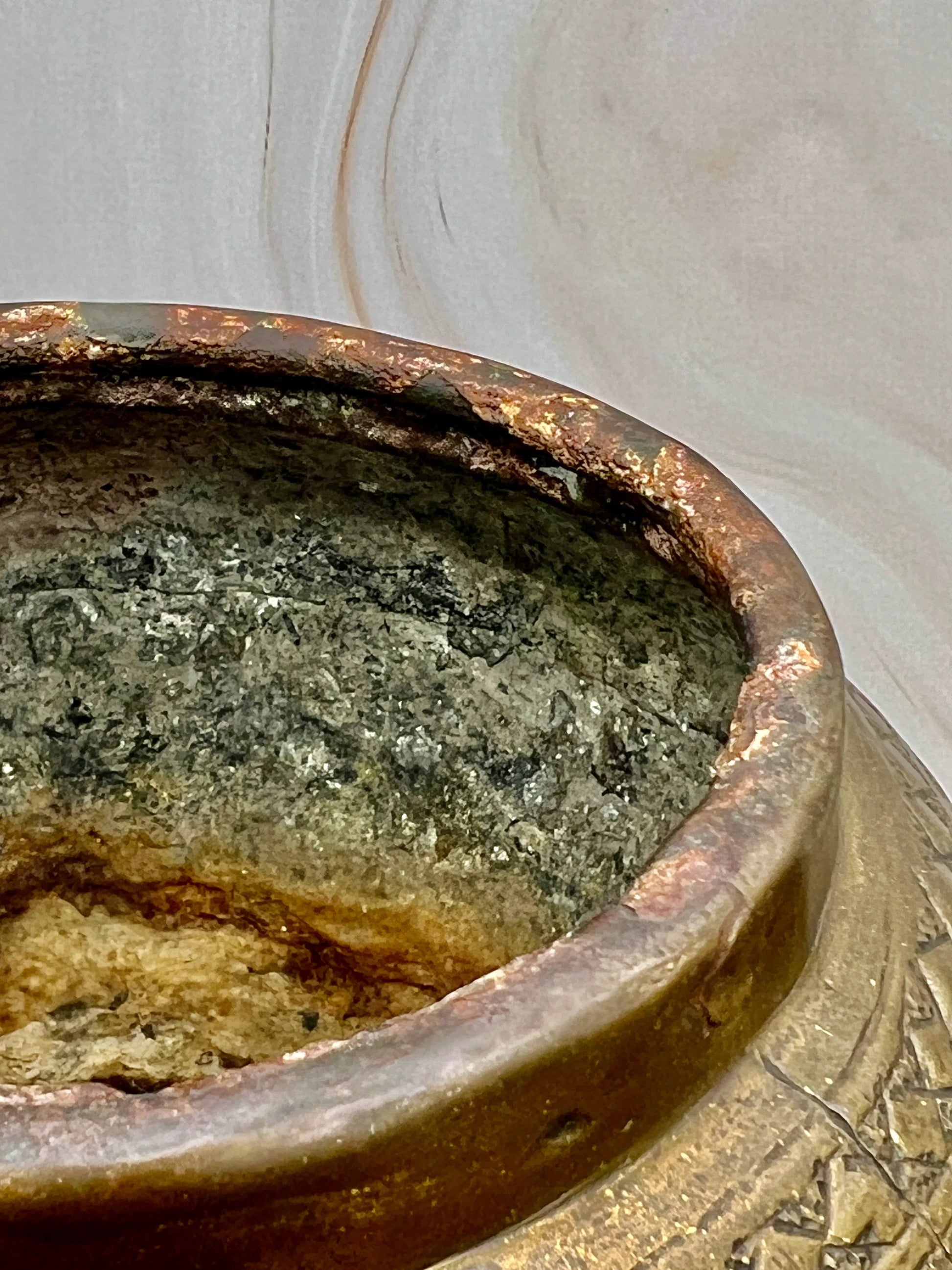 Close-up of a rusted metal pot with a blurred background