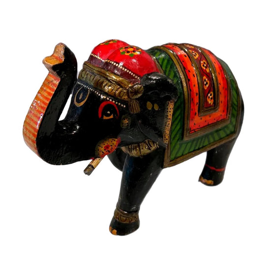 Angled view of black wooden elephant with red and green painted saddle
