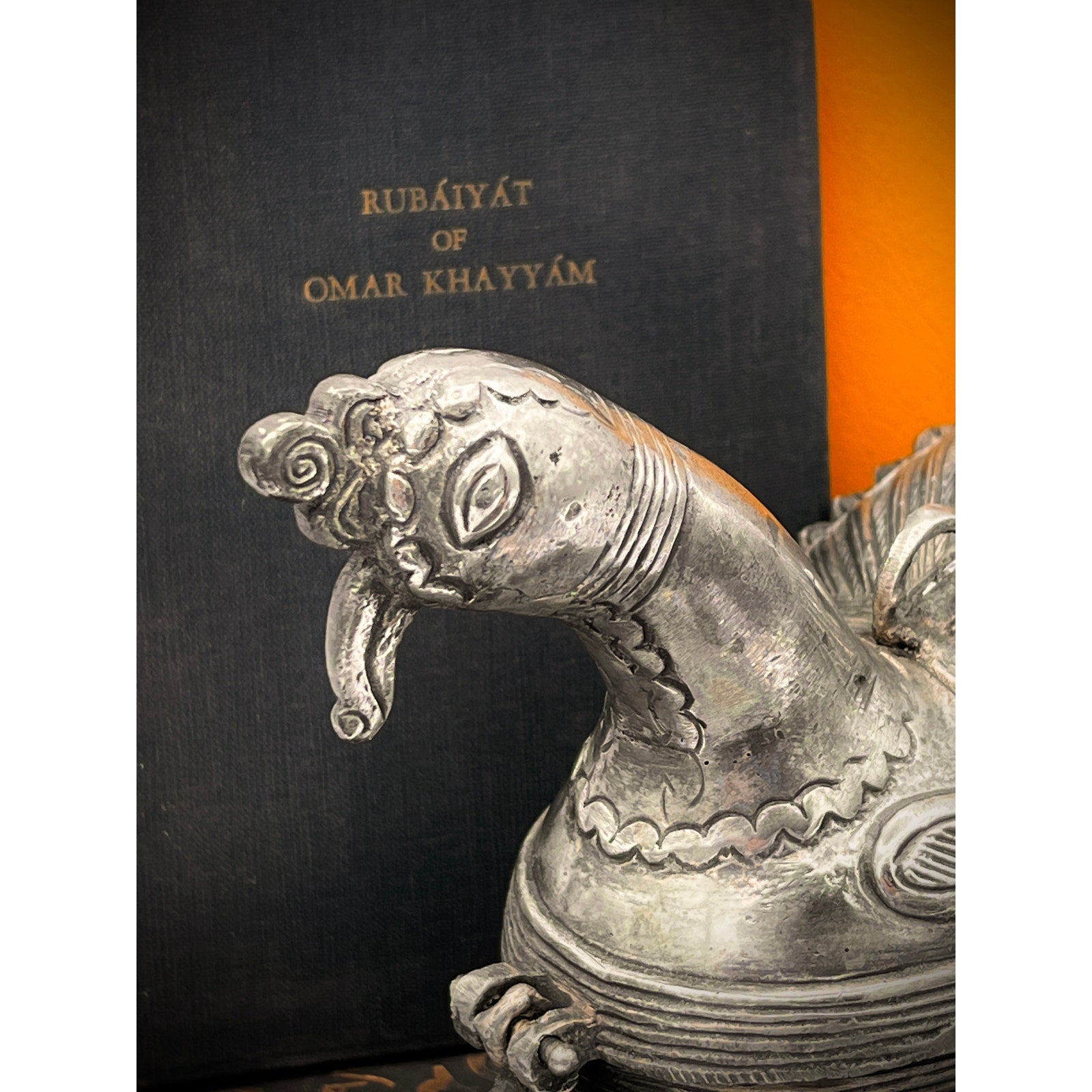 Decorative metal sculpture in front of a book titled 'Rubaiyat of Omar Khayyam'