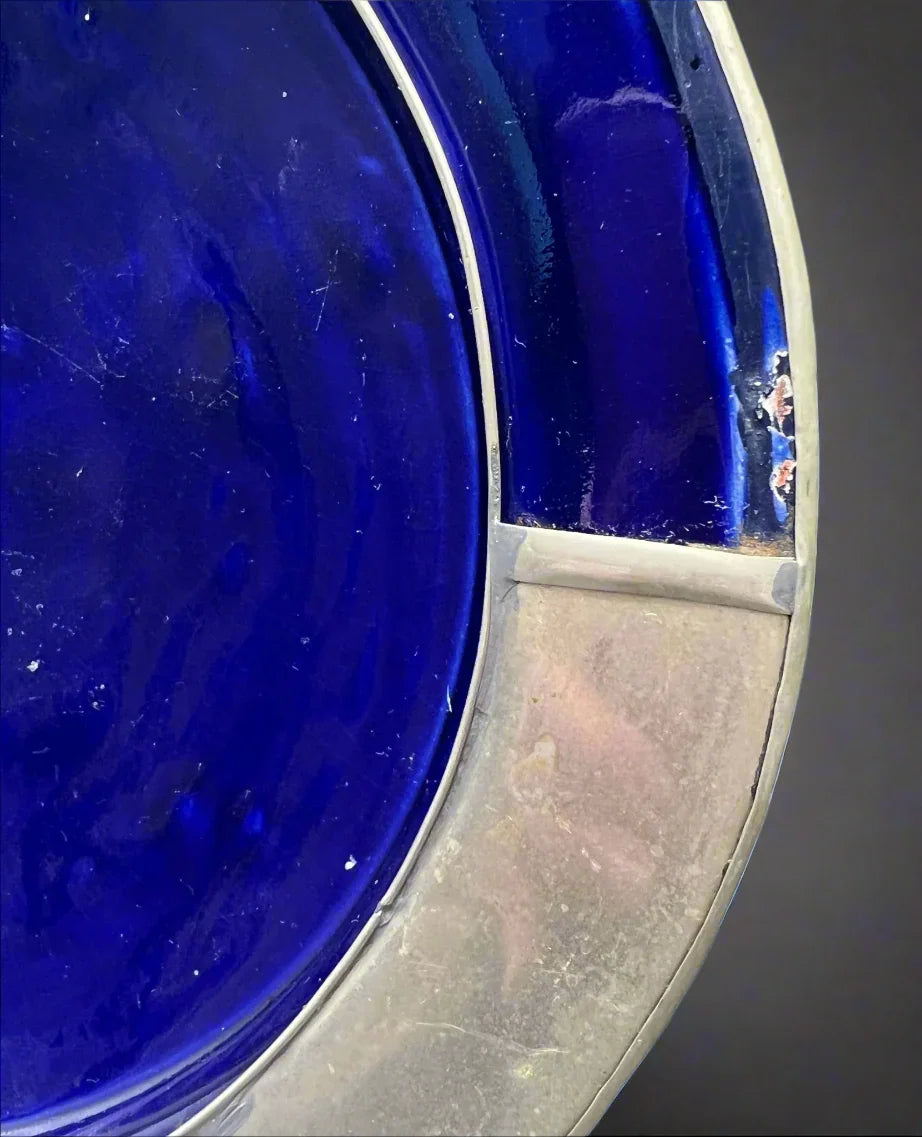 Close-up of a blue glass bowl with a metallic rim