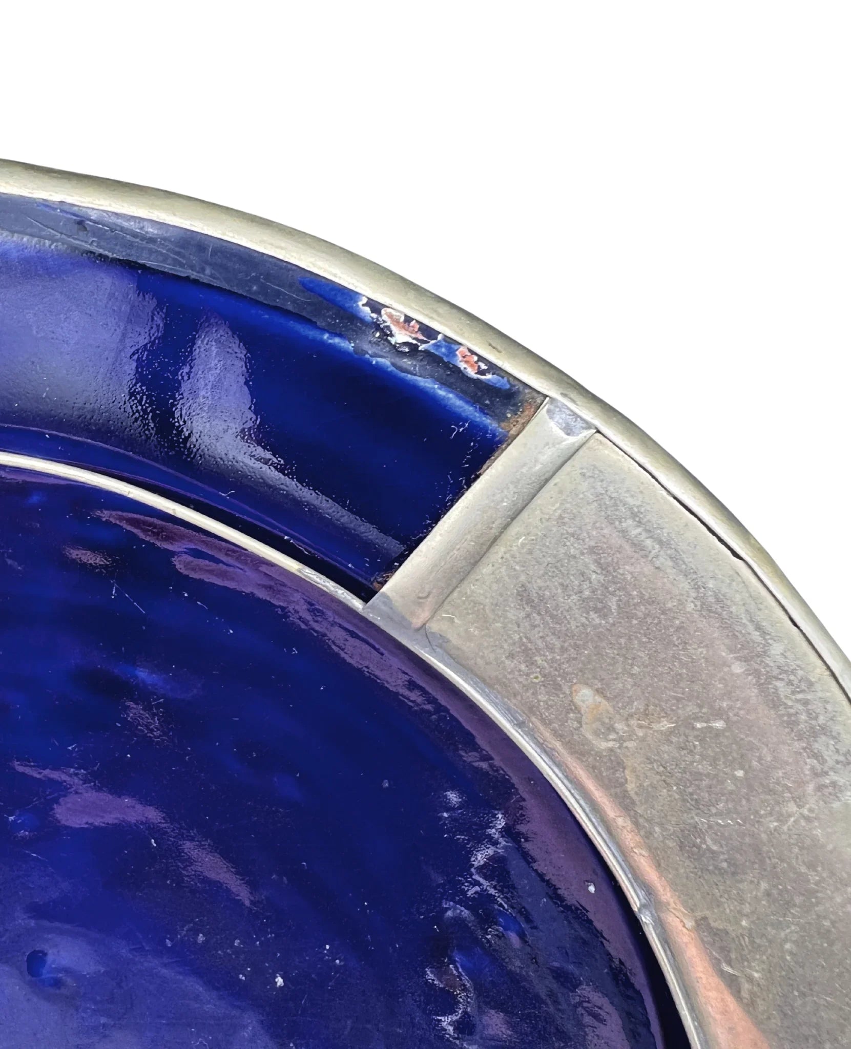 Close-up of a blue glass bowl with a metallic rim on a white background