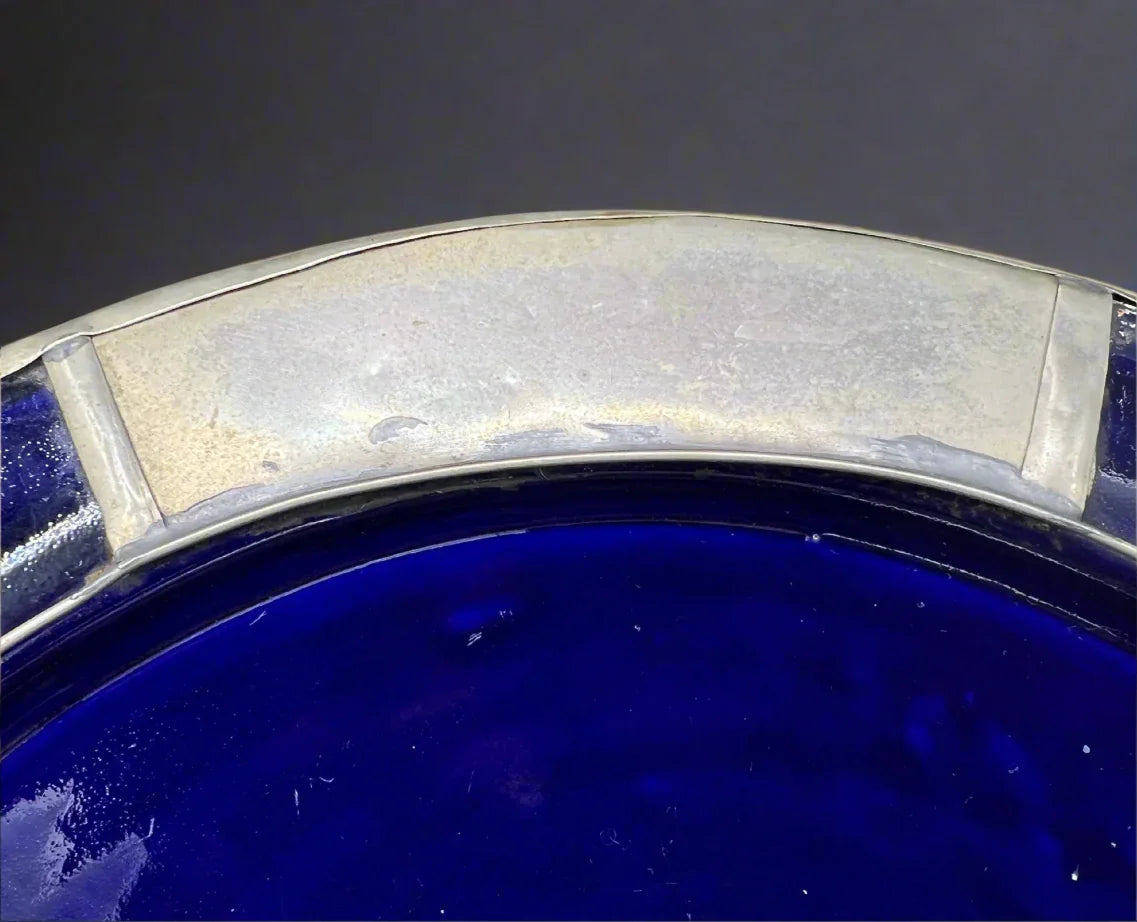 Close-up of a blue glass bowl with a silver rim on a white background