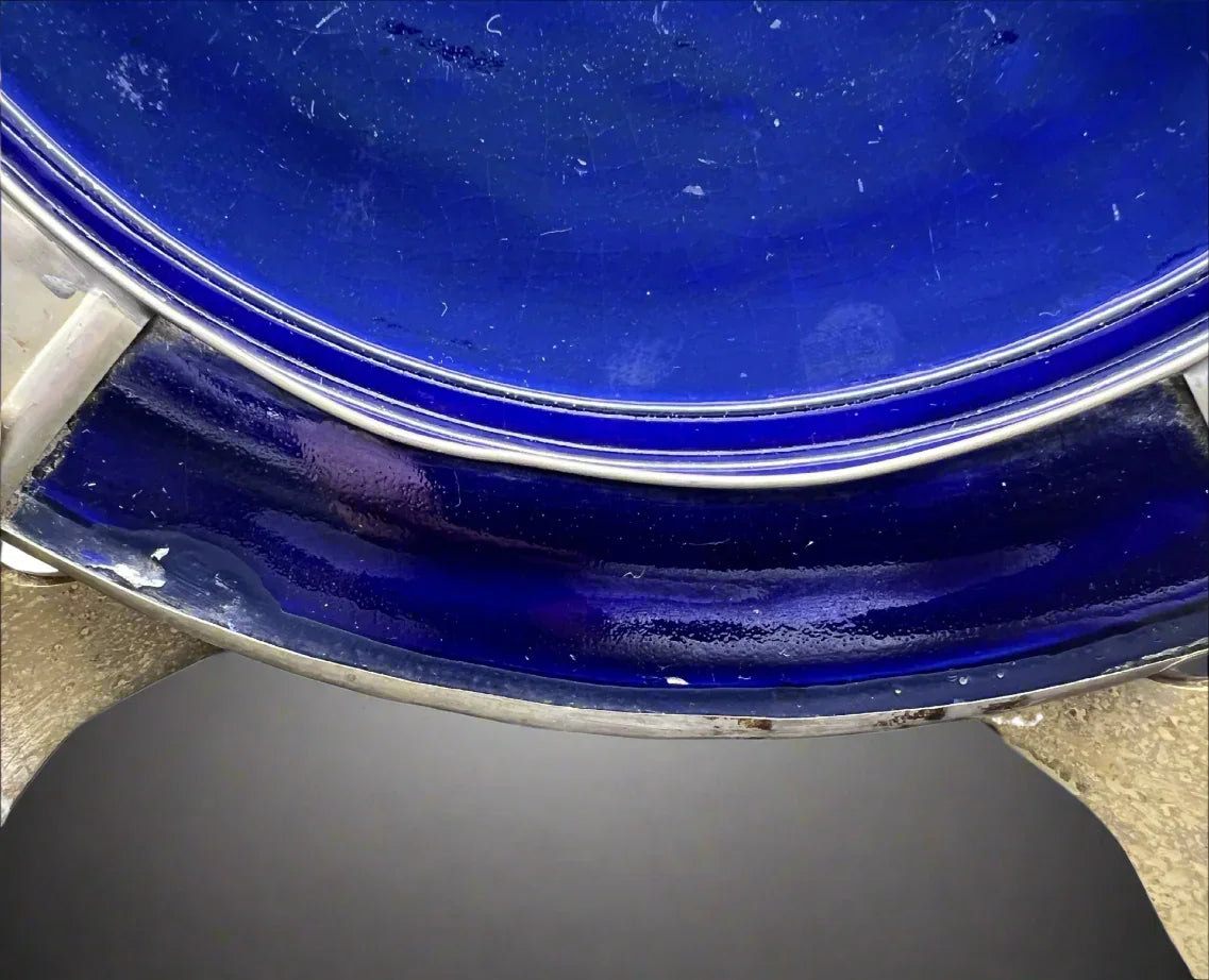Close-up of a blue ceramic plate with a metallic rim on a white background